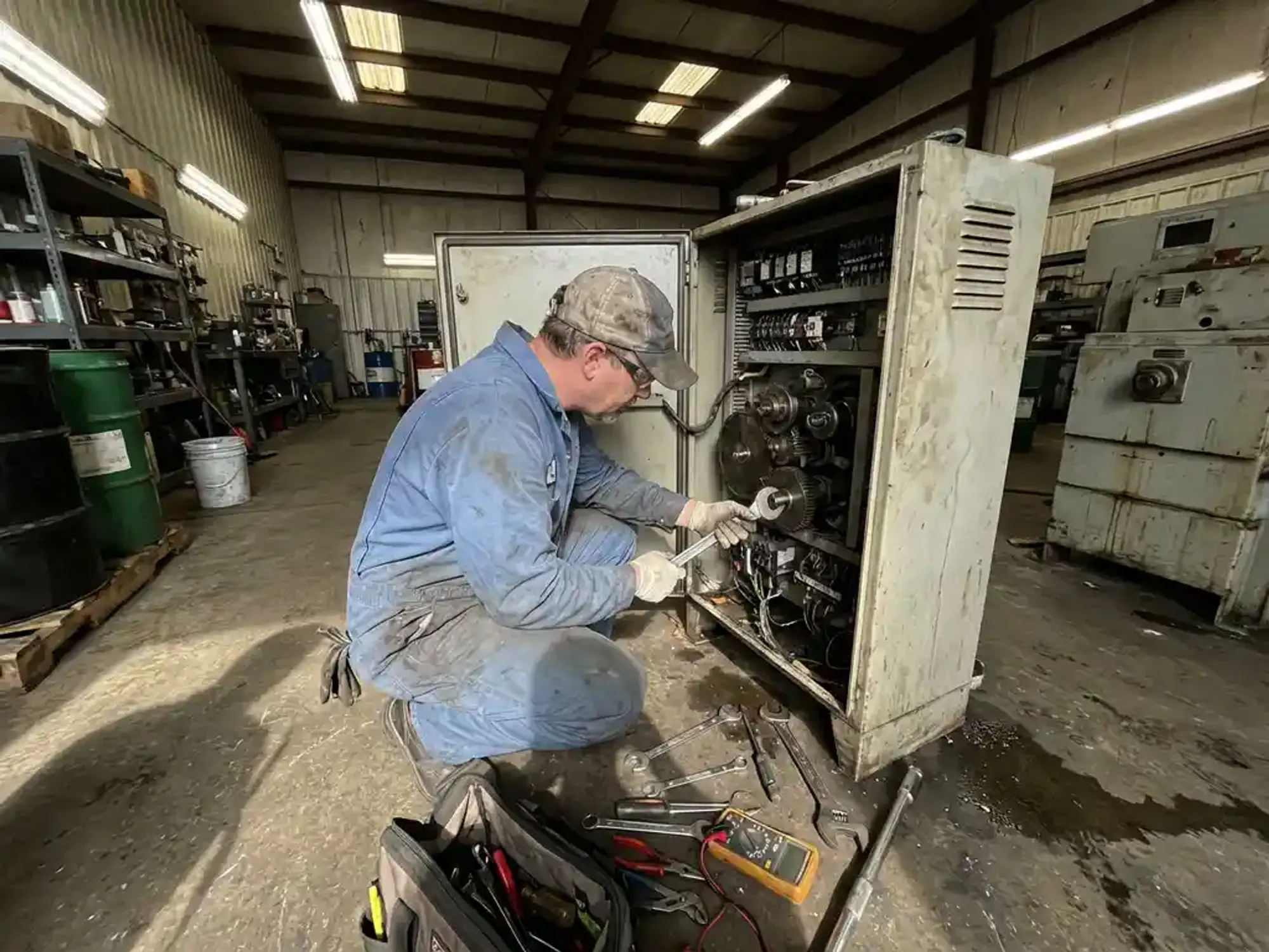 Onderhoudstechnicus repareert industriële machine met gereedschap in werkplaats